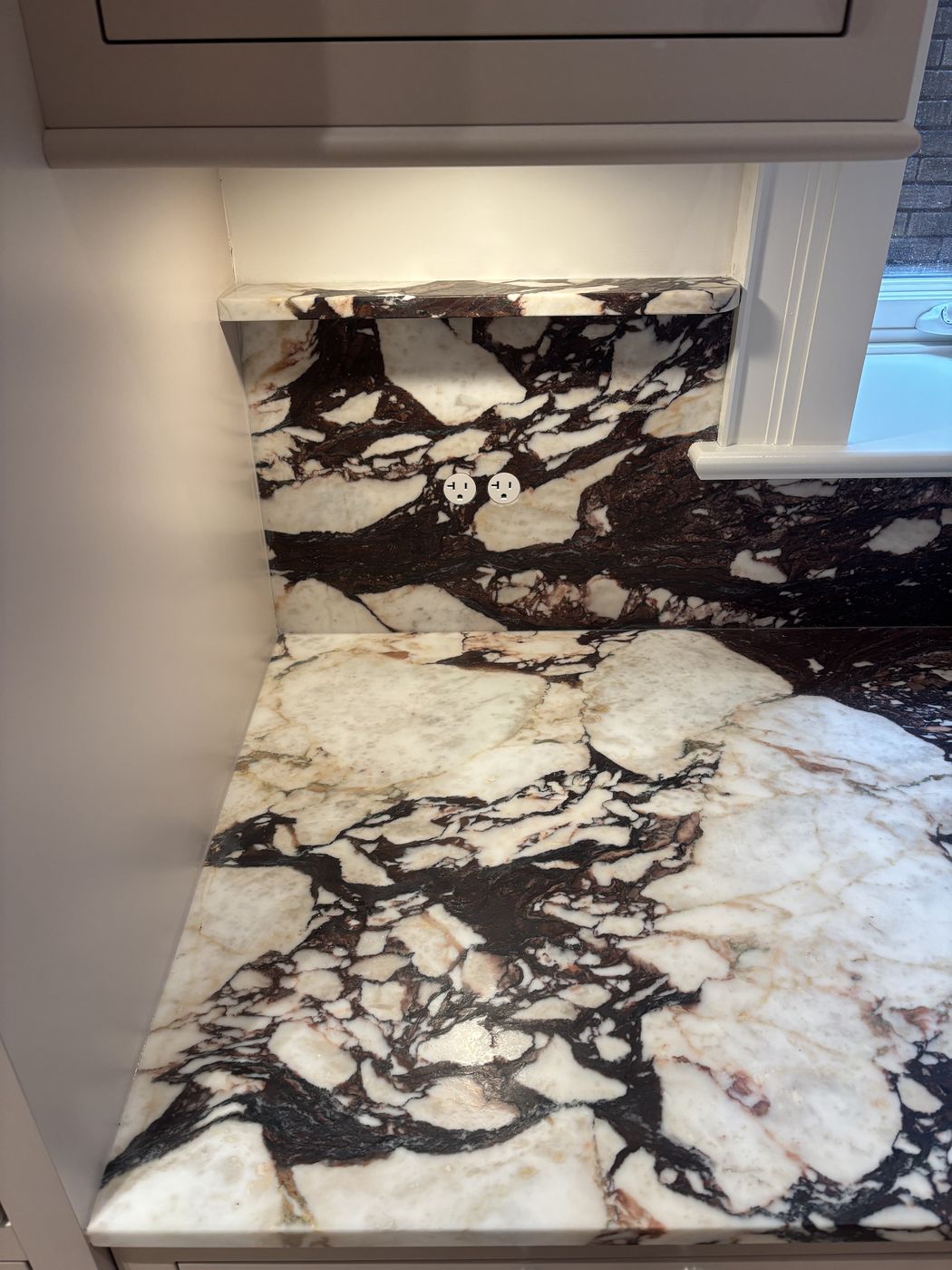 Bocci flush outlets in marble backsplash